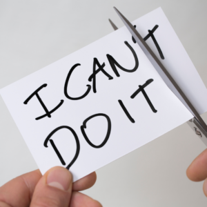 Cutting “I can’t do it” message with scissors symbolizing breaking limiting beliefs for weight loss success